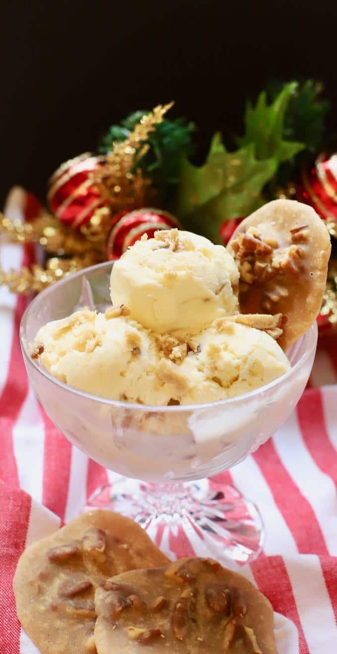 Three scoops of pecan praline ice cream in a glass dish.