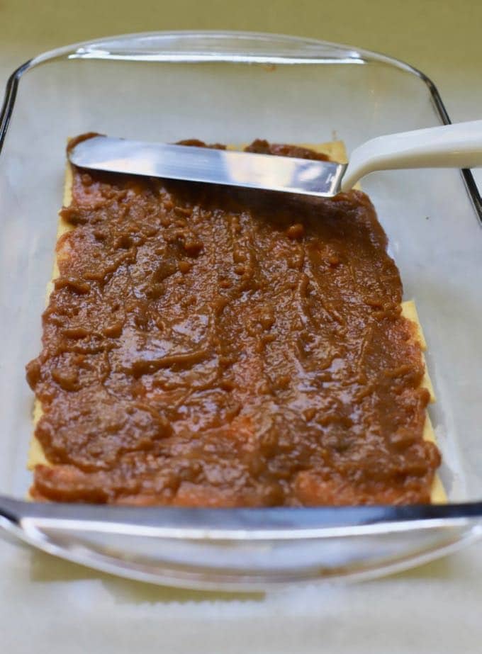 A layer of crackers and a layer of graham cracker and sugar in a dish to make homemade copycat kit kat bars.