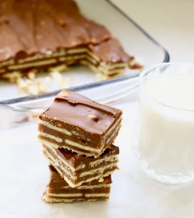 A stack of three homemade kit kat bars with a glass of milk.