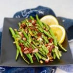 A plate of Roasted Green Beans with Bacon and Lemon.