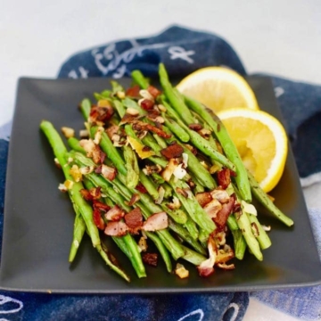 A plate of Roasted Green Beans with Bacon and Lemon.