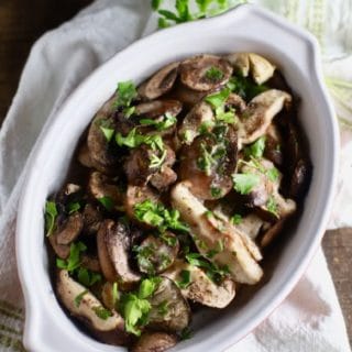 Baked Mushroom Casserole in a white baking dish garnished with parsley.