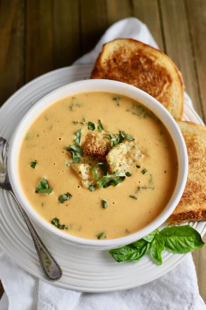 A bowl of tomato soup with a grilled cheese sandwich.
