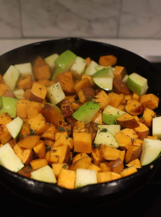 Cooking sweet potatoes and apples in a cast iron skillet.