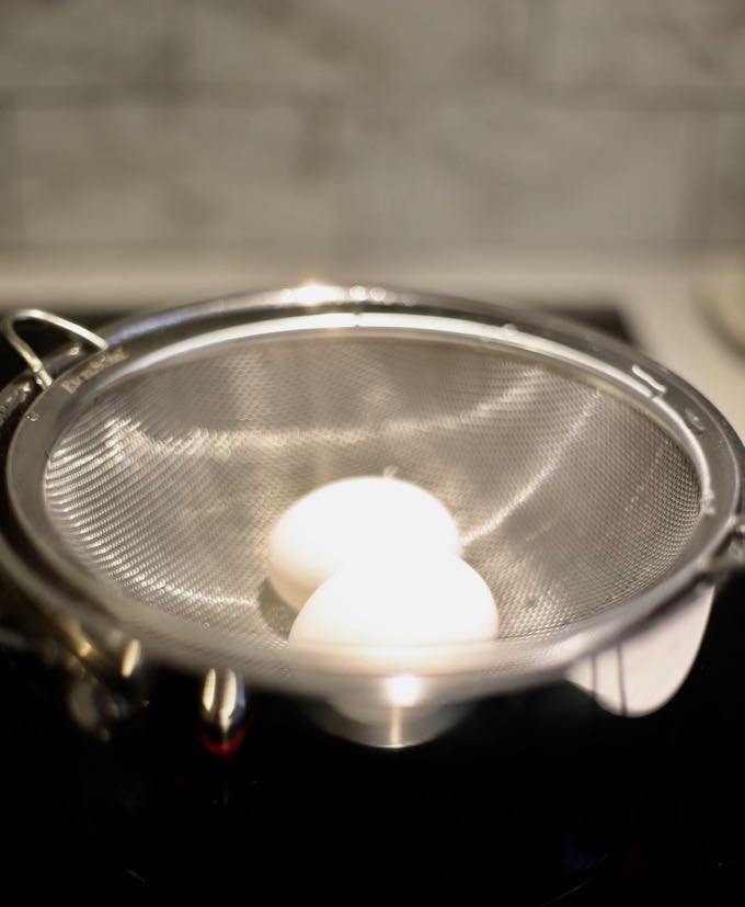 A wire strainer in a saucepan to make steamed eggs.