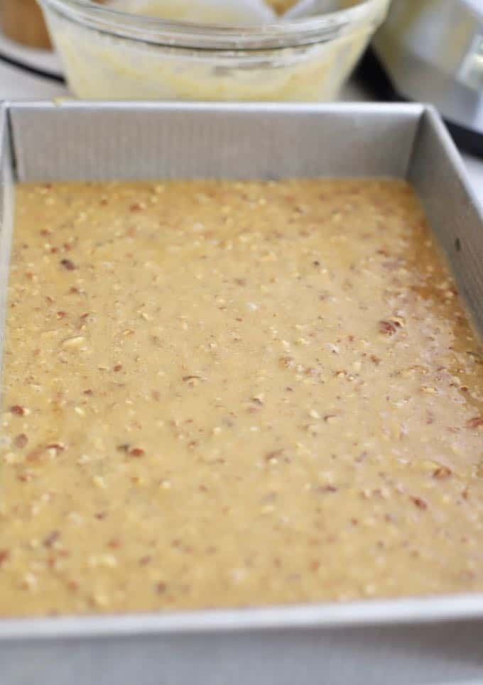 Cake batter in a rectangle metal baking pan.