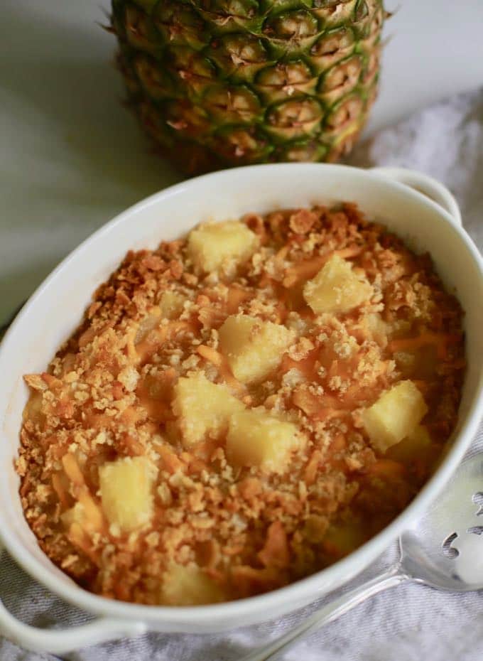 A white serving dish with a baked pineapple casserole