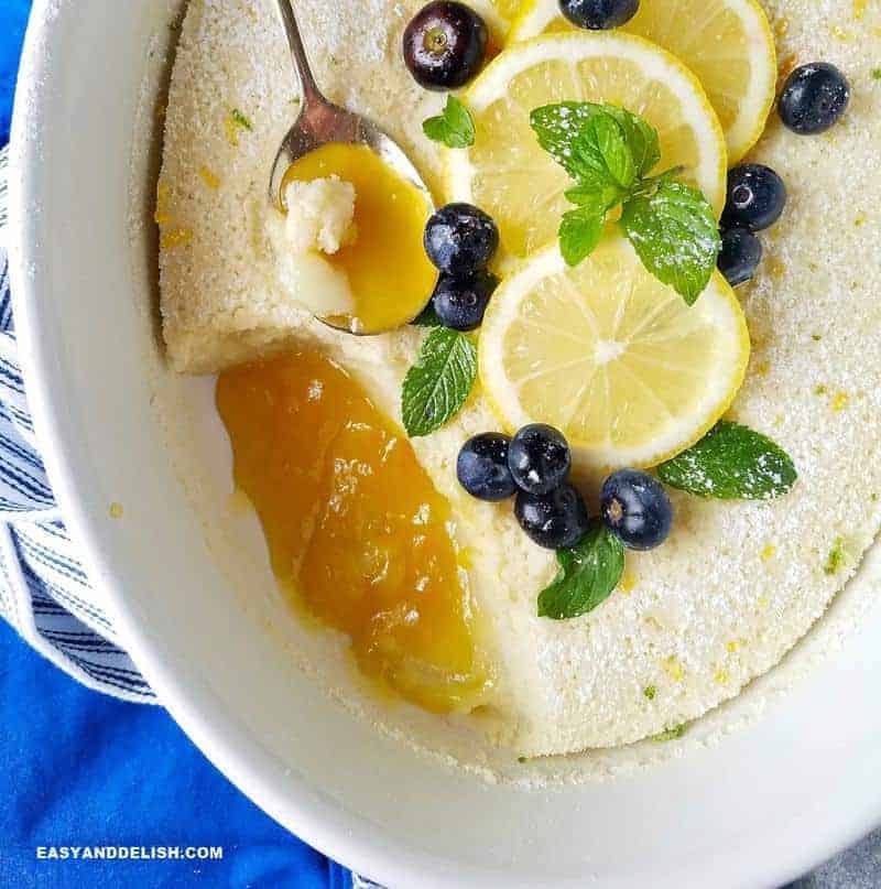 Lemon pudding cake topped with blueberries and lemon slices. 