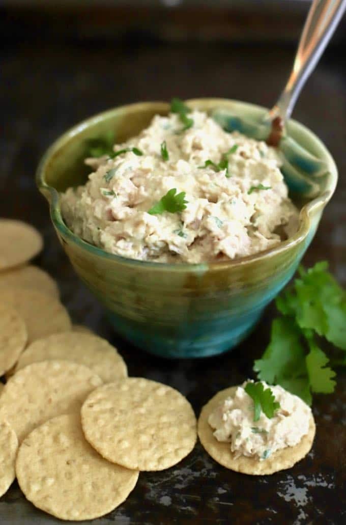 A blue bowl full of deviled ham and crackers below it.