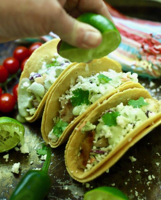 Squeezing lime juice over grilled fish tacos.