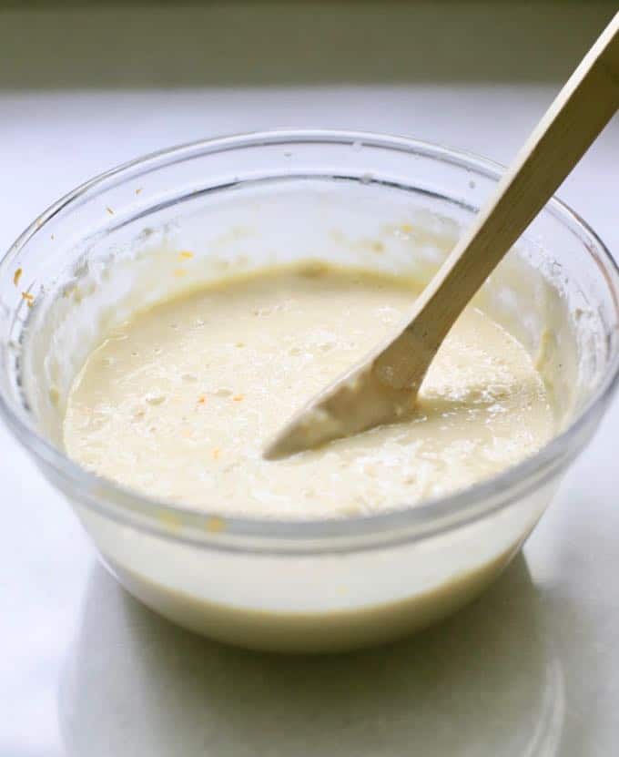 Ingredients for lemon bread with lemon glaze being mixed in a bowl.