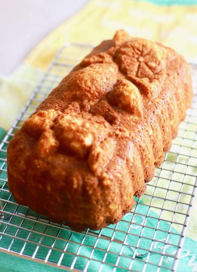 A loaf of lemon bread cooling on a wire rack. 