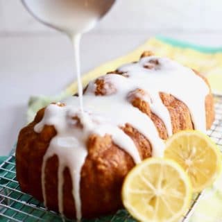 Lemon bread with lemon glaze being poured over it.