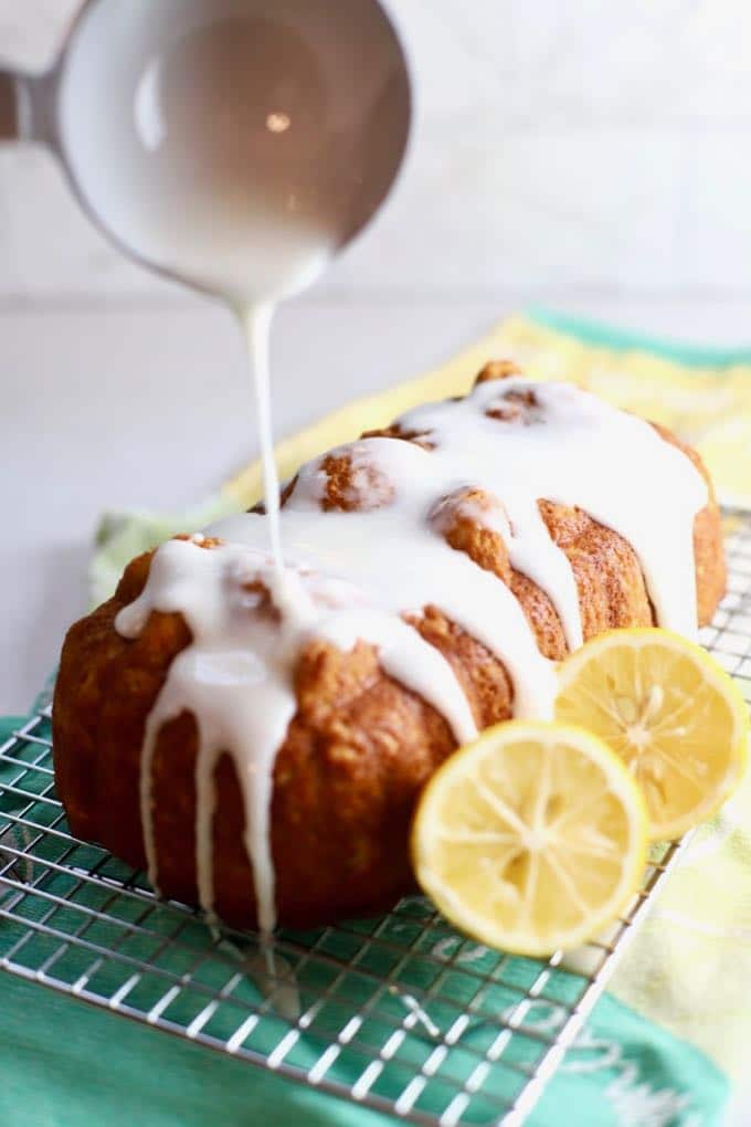 Lemon bread with lemon glaze being poured over it.