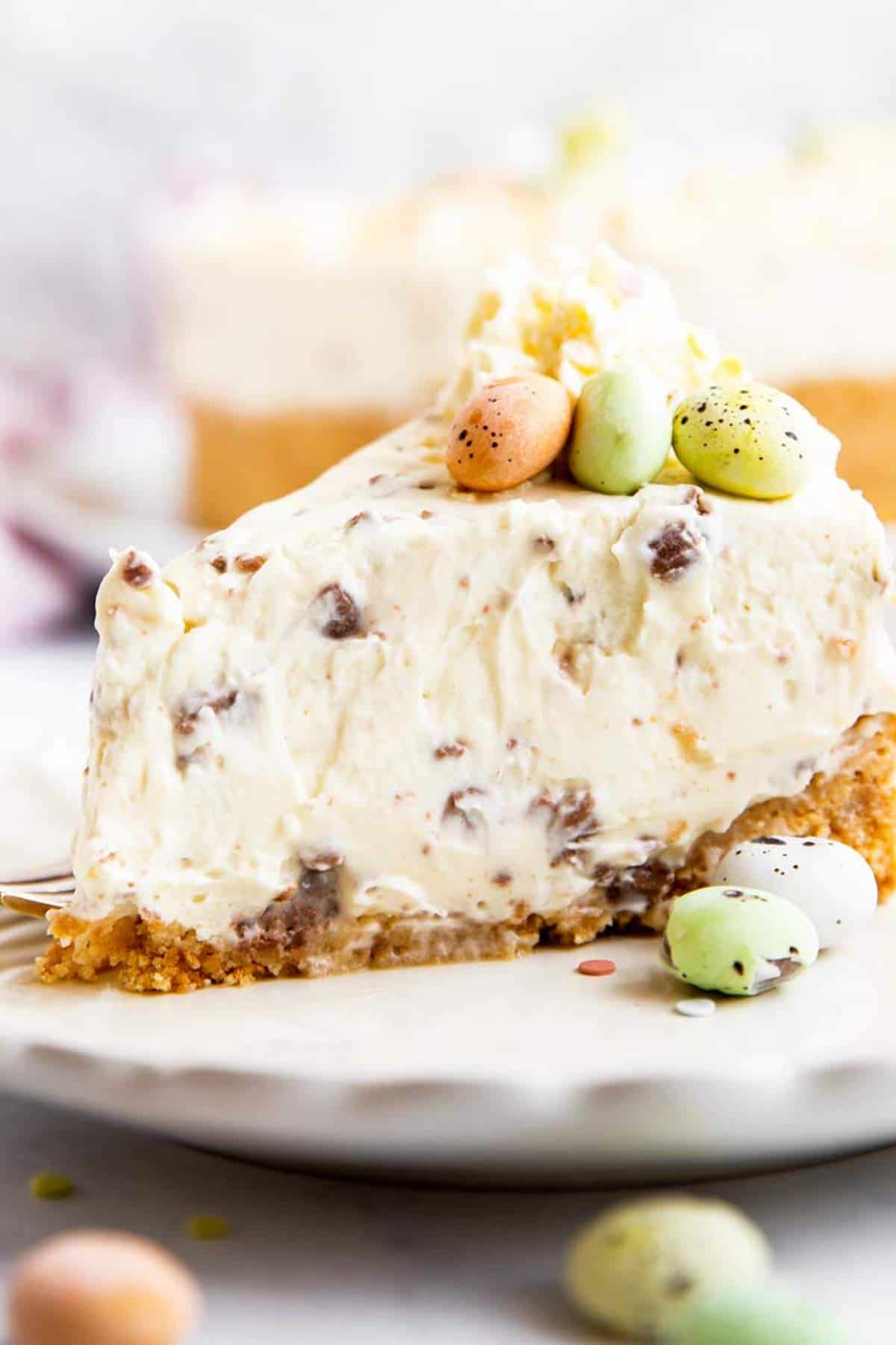 A slice of cheesecake topped with Easter candy. 