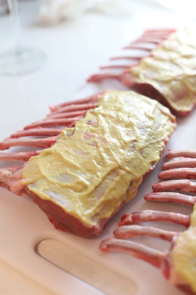 Racks of lamb topped with dijon mustard.