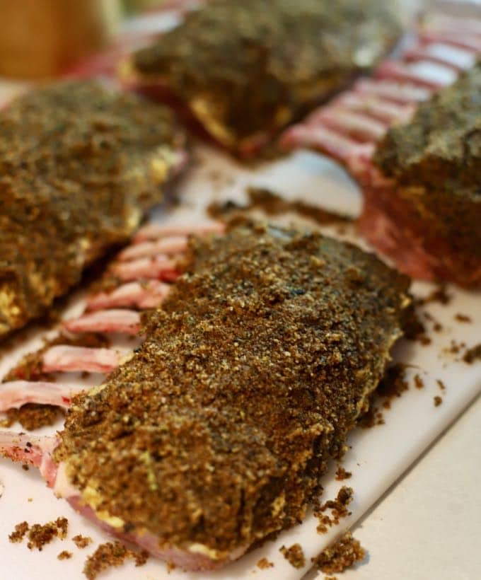 Racks of lamb topped with a herb and breadcrumb topping prior to cooking.