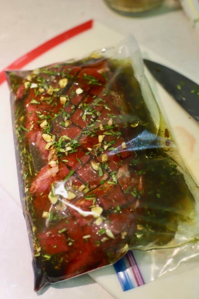 A large storage bag with a steak in marinade.