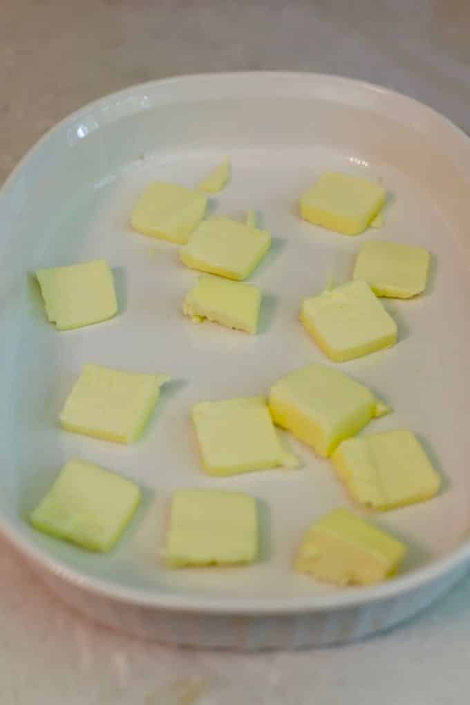 Pats of butter in a white baking dish.