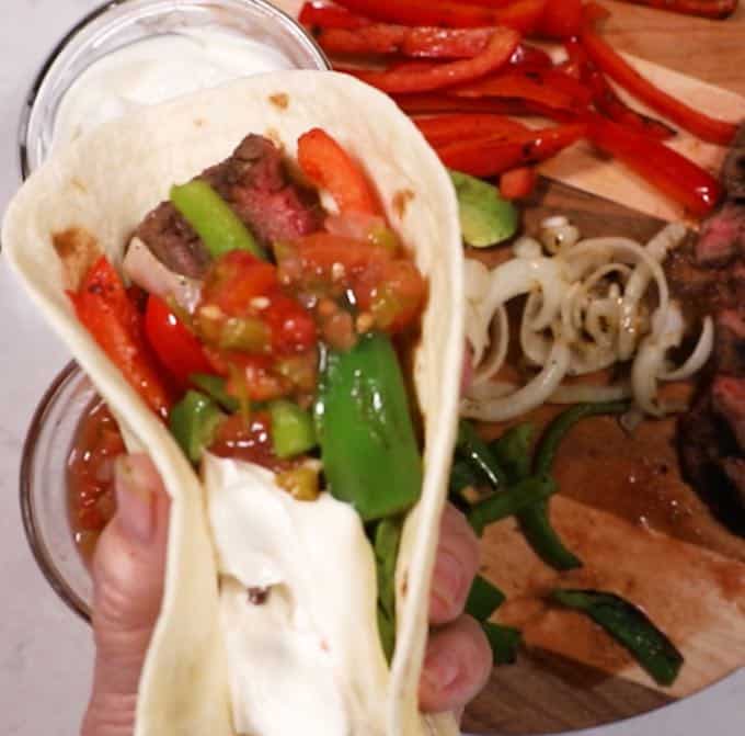 Steak fajita full of strips of steak, peppers and onions.