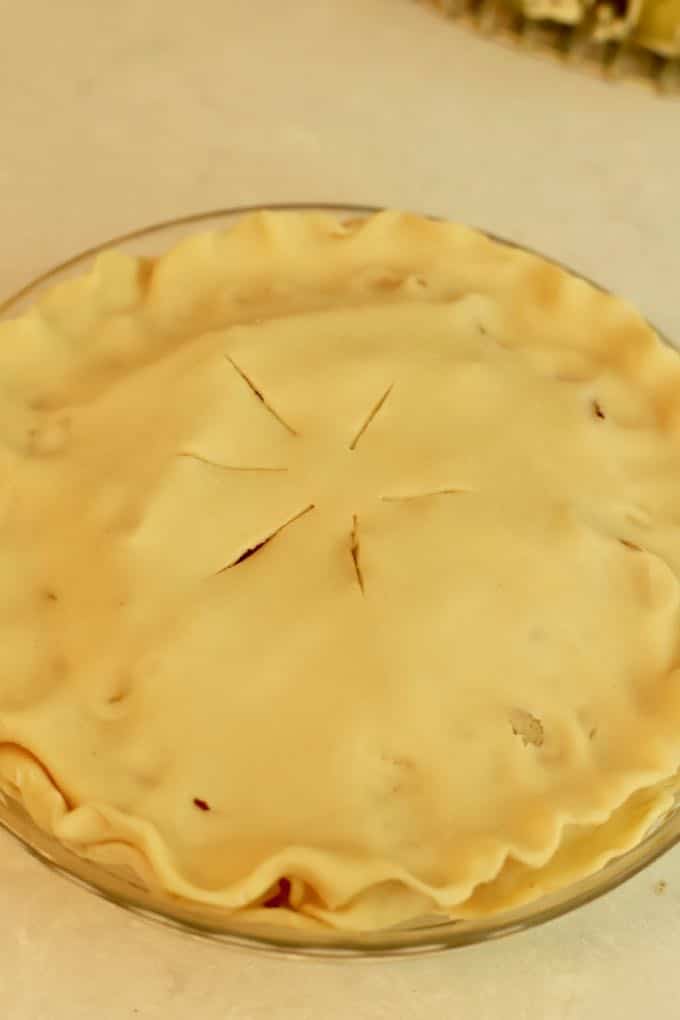 An unbaked pear pie with a top crust ready for the oven. 