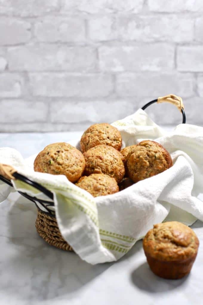 Zucchini Banana Muffins in a basket on a kitchen counter.
