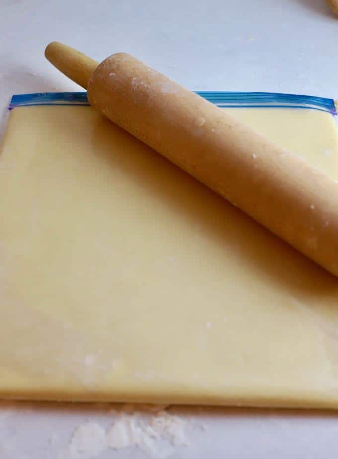 Shortbread cookie dough in a gallon storage bag and a rolling pin.