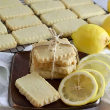 Lemon shortbread cookies on a bronze metal plate with lemon slices.