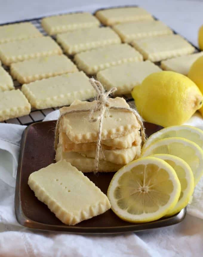 Lemon shortbread cookies on a bronze metal plate with lemon slices.