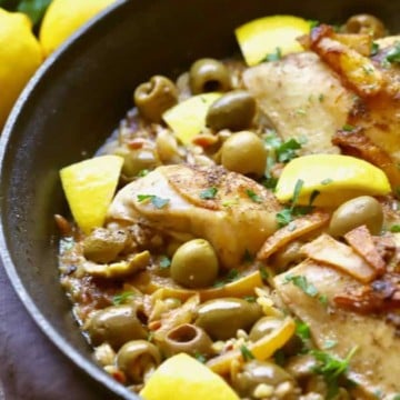 Chicken, lemons, olives and pasta in a skillet for Mediterranean Chicken Bake.