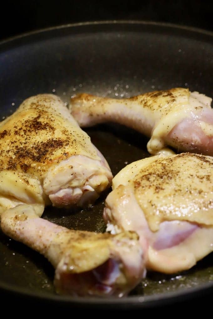 Pan-searing chicken in a skillet on the stove. 