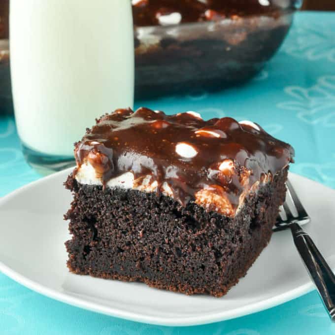 A slice of Mississippi Mud Cake on a white plate with a fork.
