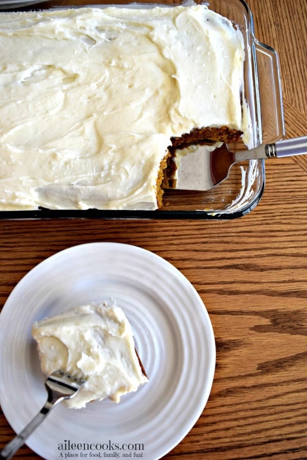 A glass baking dish with pumpkin sheet cake on a board.