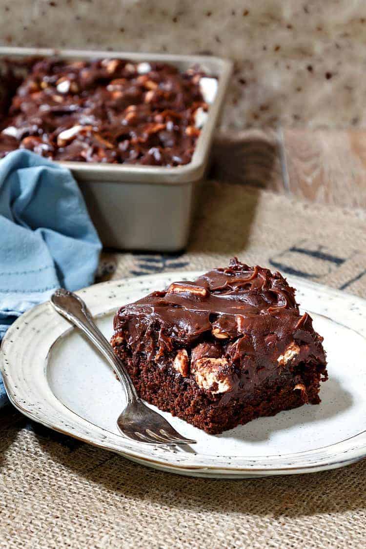 A slice of chocolate mayonnaise cake on a white plate with a fork.