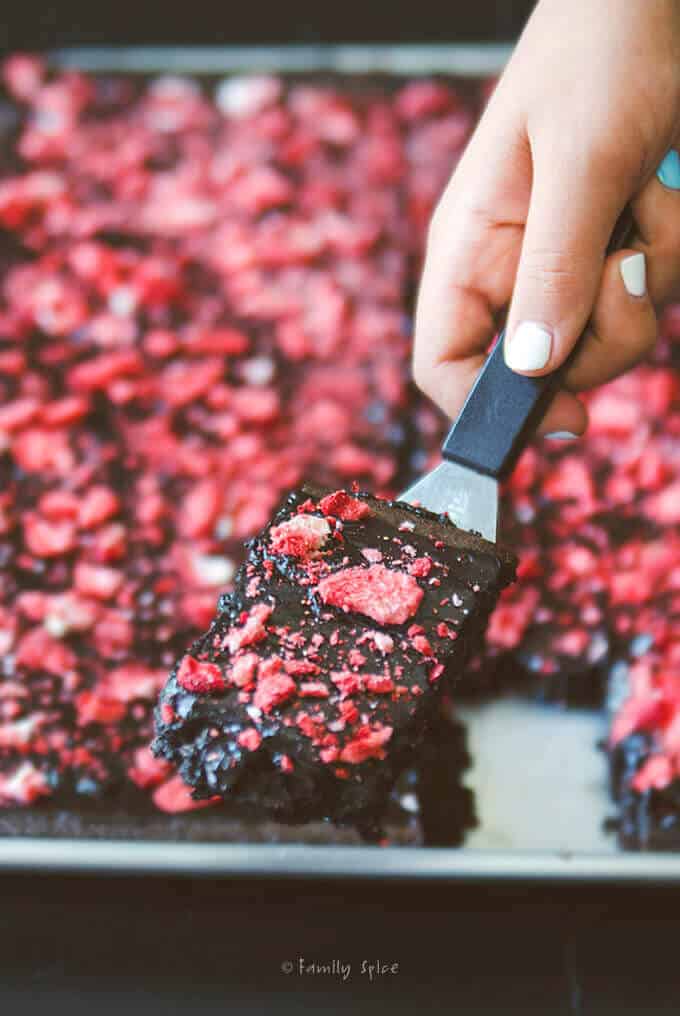 Cutting a slice of Chocolate Strawberry Sheet Cake.