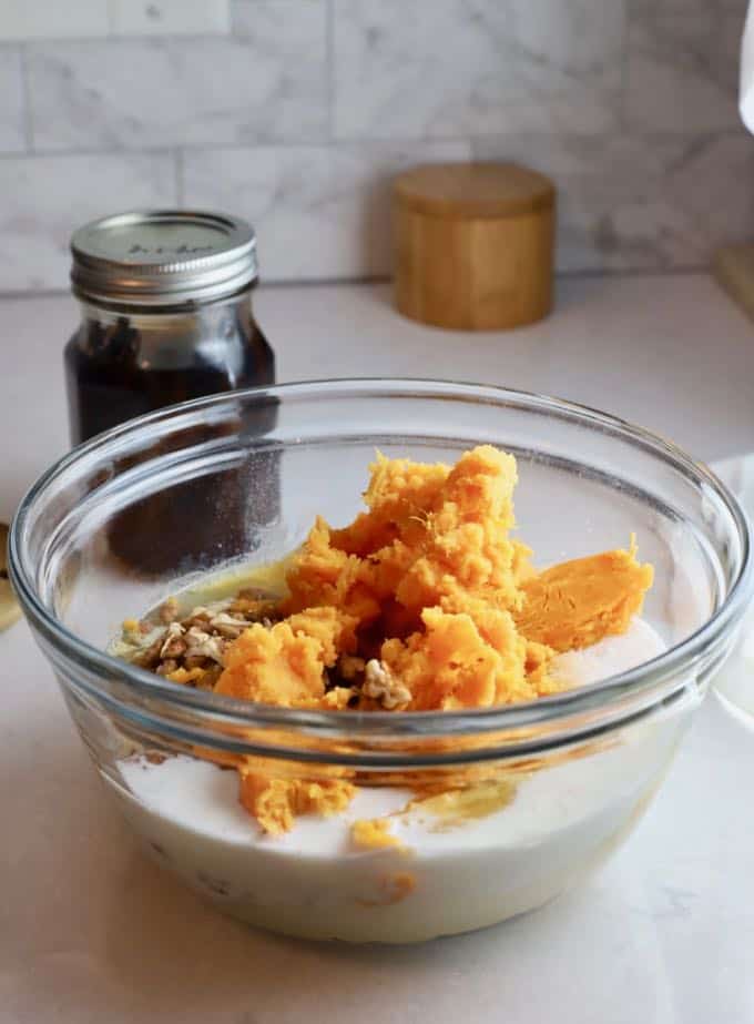 Sweet potatoes, flour, sugar, eggs and pecans in a bowl to make sweet potato bread.