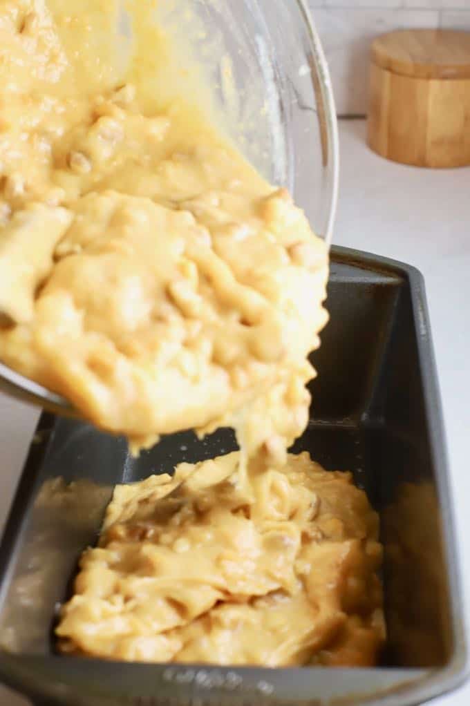 Pouring sweet potato bread batter into a loaf pan.