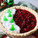 Christmas Cranberry Pie full of cranberry filling and topped with whipped cream and candy Christmas trees.