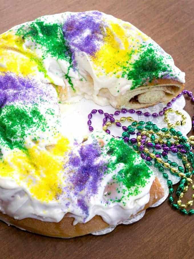 A mardi gras king cake decorated in yellow, green, and purple.