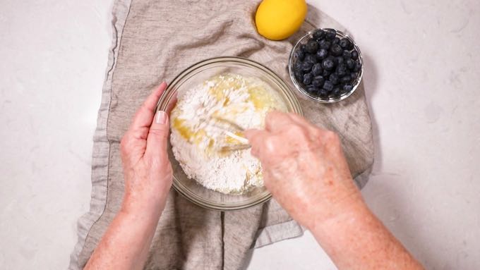 Mixing flour and butter in a clear glass bowl. 