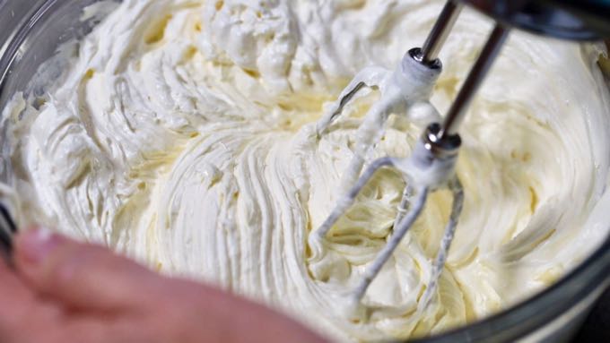 Whipping frozen whipped topping with cream cheese and sugar with an electric mixer. 