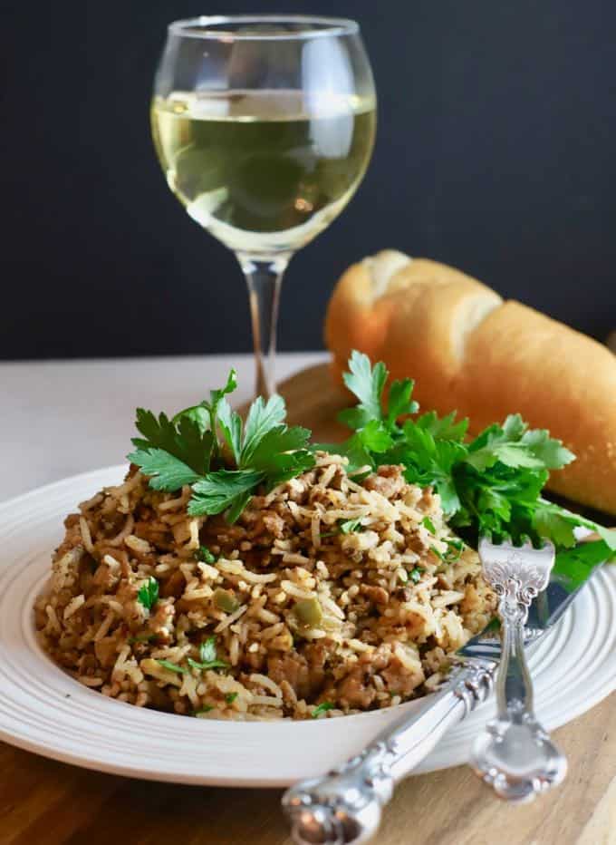 Dirty rice topped with parsley and a glass of wine.