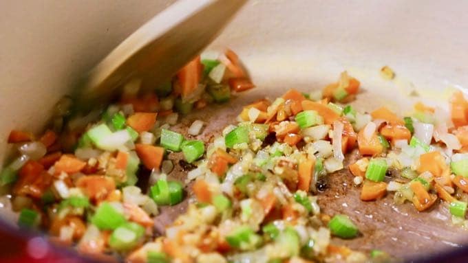 Carrots, celery, and onions cooking in a Dutch oven.