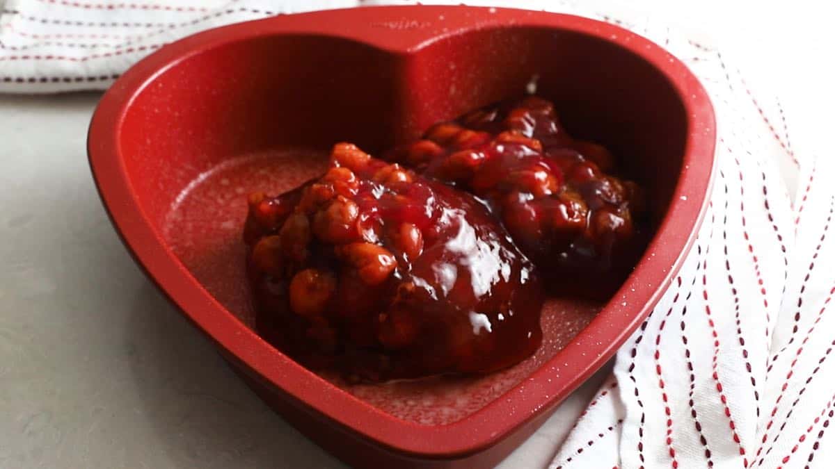 Cherry pie filling in a heart shaped baking pan. 