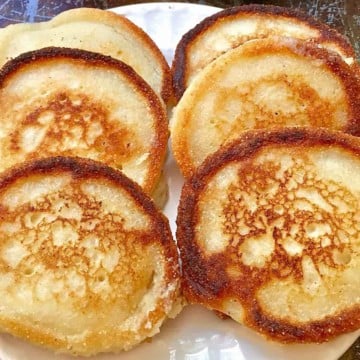 Six hoecakes or fried cornbread on a white plate.