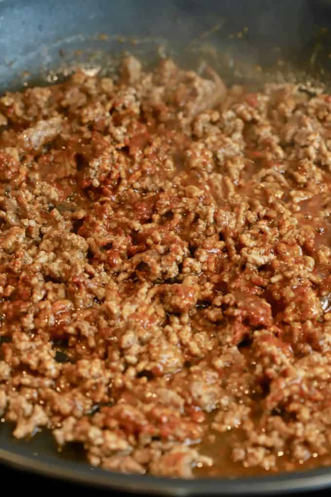 Ground chuck in a skillet cooked with taco seasoning. 