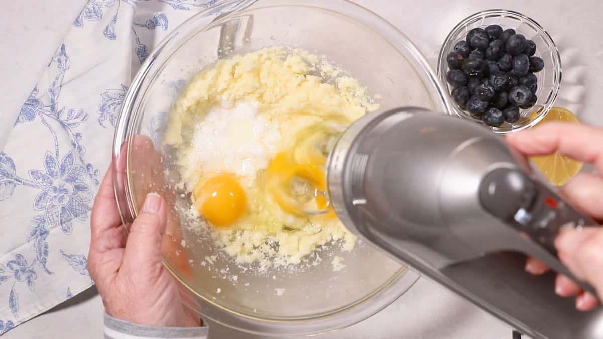 Sugar, butter, and eggs in a mixing bowl. 