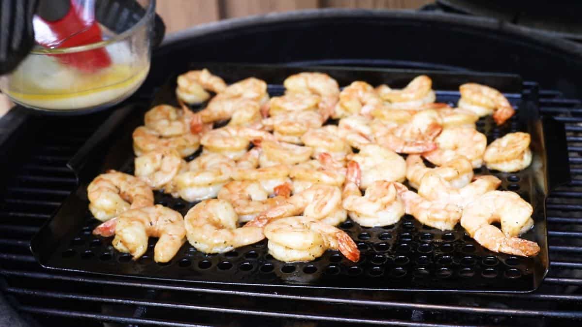 Shrimp in a grill basket on a grill.