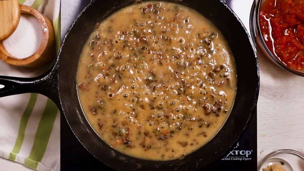 Gravy cooking in a cast-iron skillet.