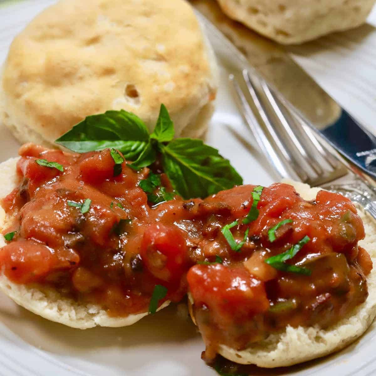 Two biscuit halves topped with tomato gravy. 
